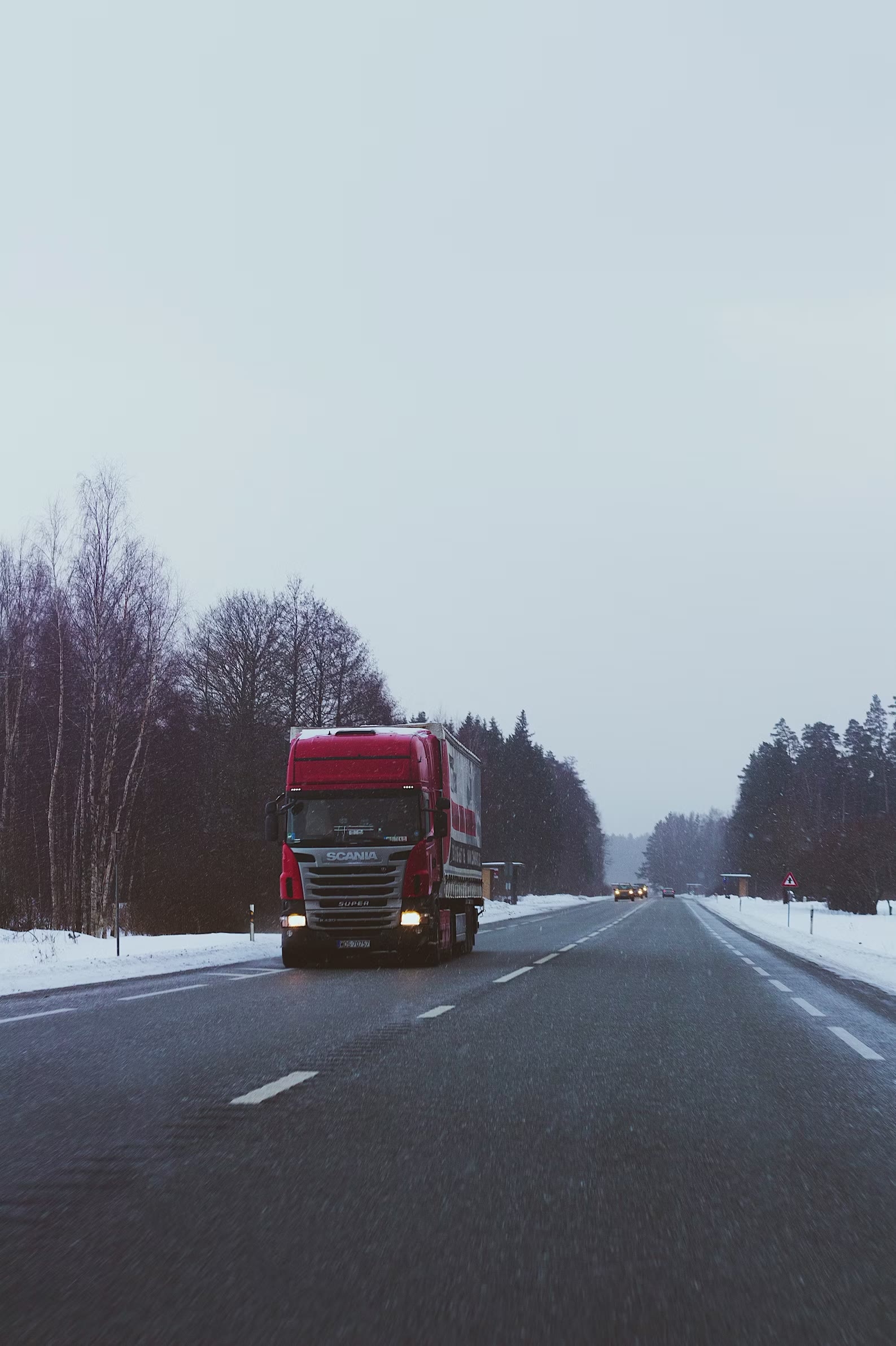 Red Scania truck travelling on a winter road